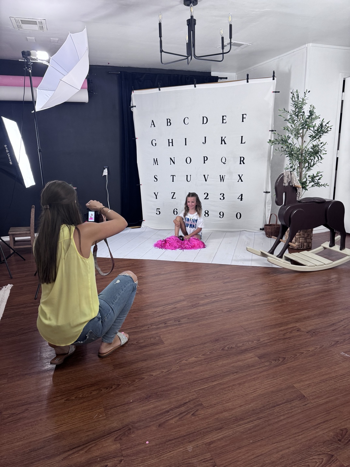 Photographer creating a studio portrait with backdrop and lights