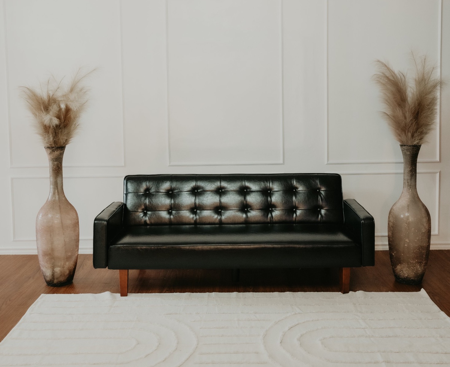 Black sofa with pampas grass in the studio